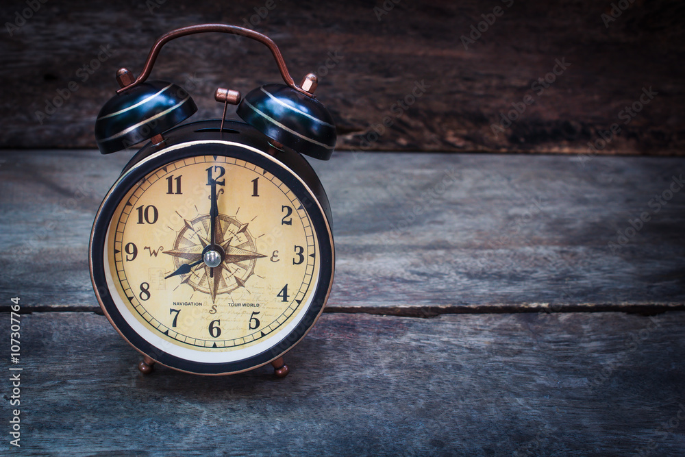 Still life with alarm clock on wood table.