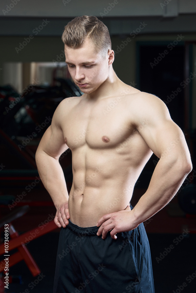 Fototapeta premium Tired muscular man posing topless in the gym