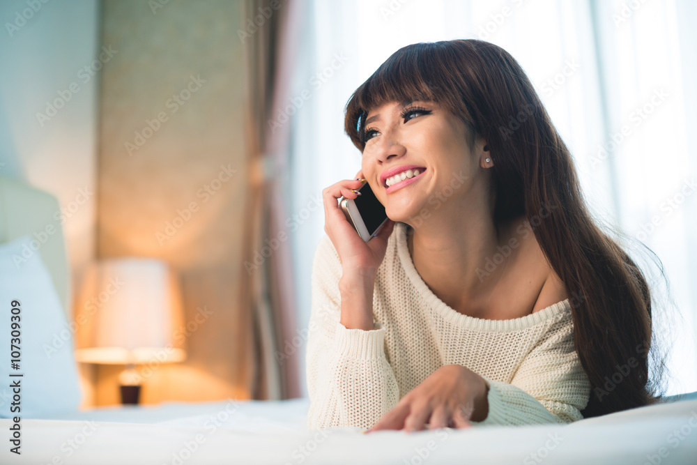 Happy attractive Vietnamese woman talking on the phone Happy attractive Vietnamese woman talking on the phone