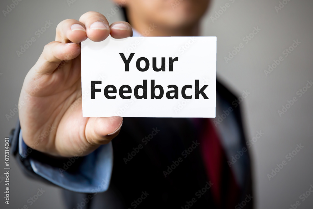 Businessman presenting 'Your Feedback' word on white card Businessman presenting 'Your Feedback' word on white card