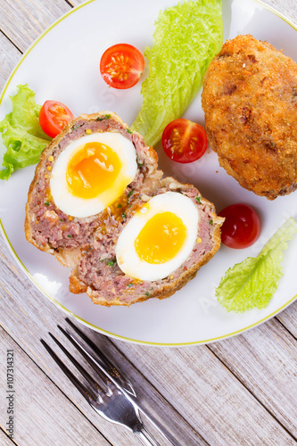 Scotch Eggs Served with Tomato Cherry and Salad on White Plate. View From Above, Top Studio Shot