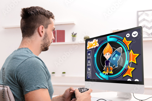 Young man playing computer ...
