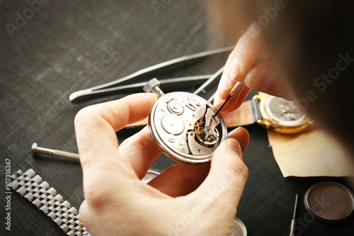 Tableau sur toile Watchmaker hands repairing mechanism of old watch closeup