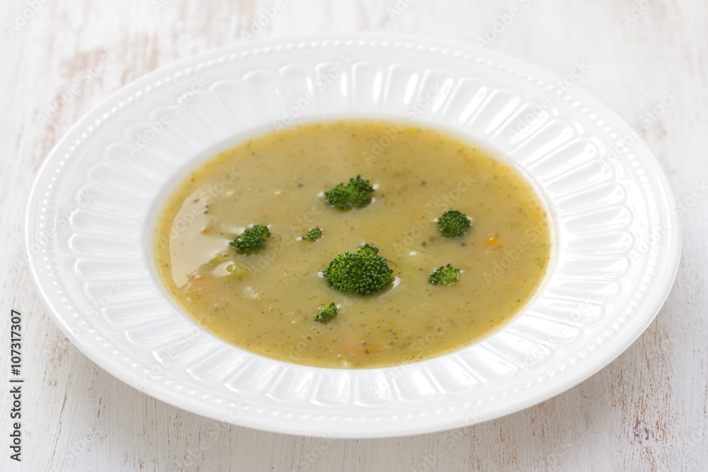vegetable soup with broccoli on white dish on white wooden background vegetable soup with broccoli on white dish on white wooden background