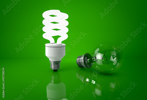 Glowing energy saving bulb and dark incandescent bulb over green