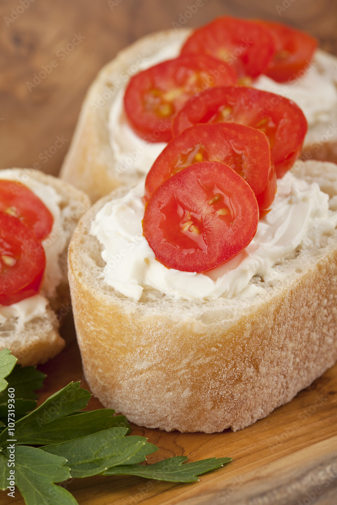 slices of baguette bread with butter spreads and tomato slices slices of baguette bread with butter spreads and tomato slices