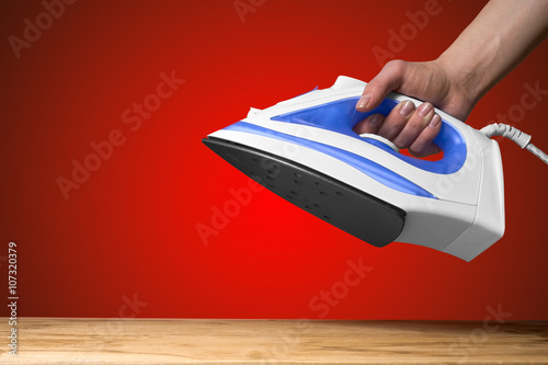 female hand holding a hot iron