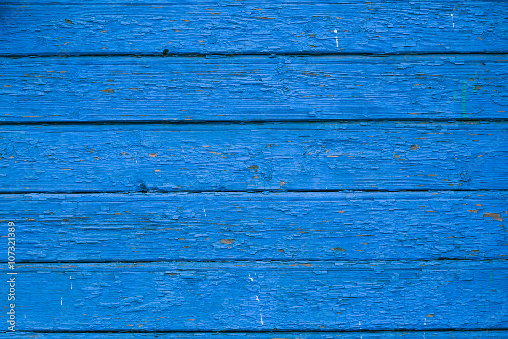 Obraz premium Old blue cracked paint on the old wooden background