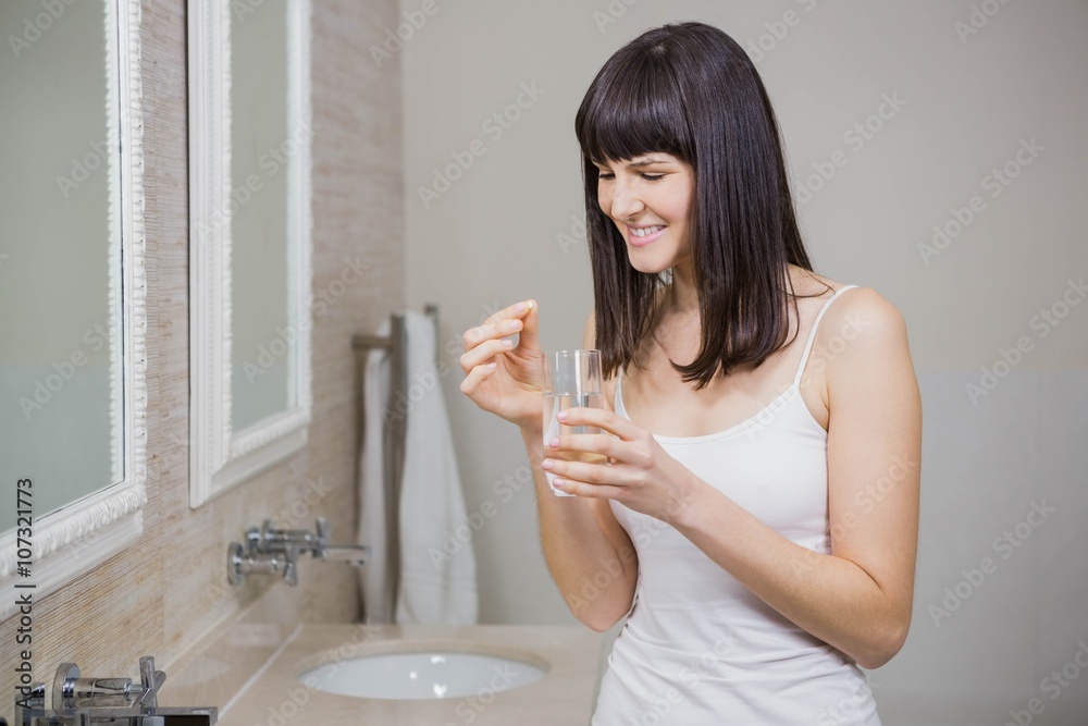 Beautiful woman holding pill and glass of water Beautiful woman holding pill and glass of water