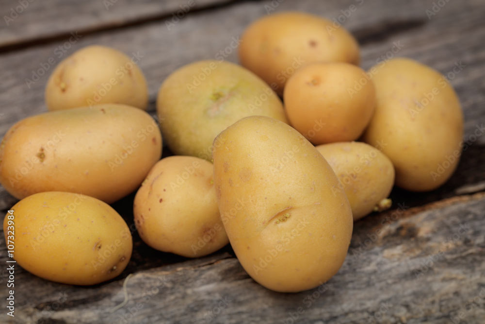 Fresh potatoes on wooden surface Fresh potatoes on wooden surface