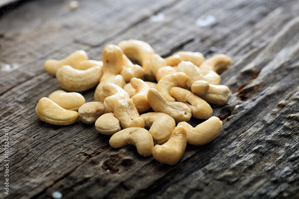 Heap of raw cashews, on wooden surface Heap of raw cashews, on wooden surface