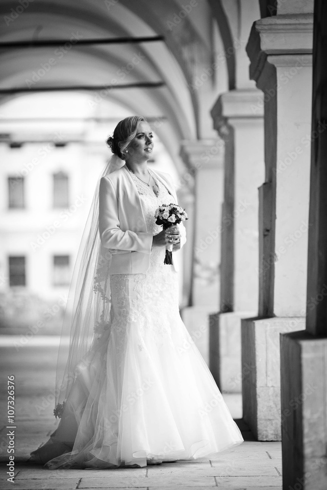 stylish blonde bride is holding amazing bouquet of roses on the