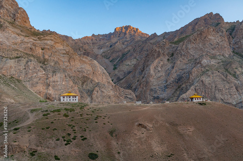 Small estranged buddhism monastery in the middle of high mountains in Ladakh, northern India. A sacred place known only by a few monks with caves in the rocks for meditation. Early morning photo.