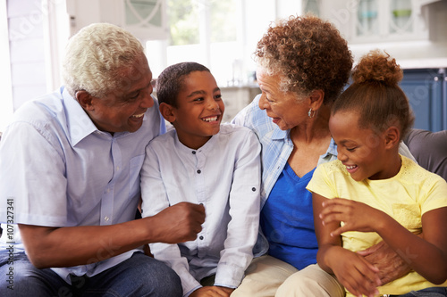 Cuadro en lienzo Grandparents and their young grandchildren relaxing at home