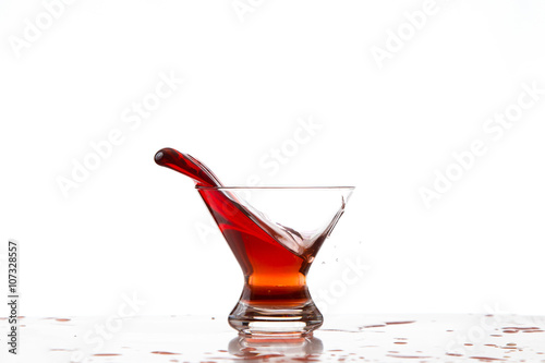 Bicchiere con liquido rosso in movimento