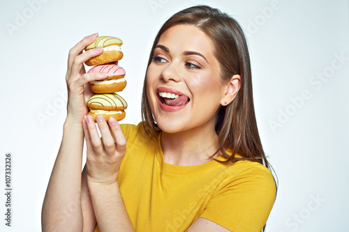 Young woman holding pile cake and licked lips by looking at the