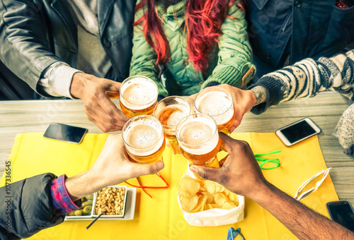 Group of friends cheers with beer cafe interior scene - Multiracial hands holding glasses of Pils in a toast to friendship and happiness -Teenager students gathering in restaurant - 