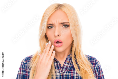 Surprised pretty girl with open mouth holding hand near face