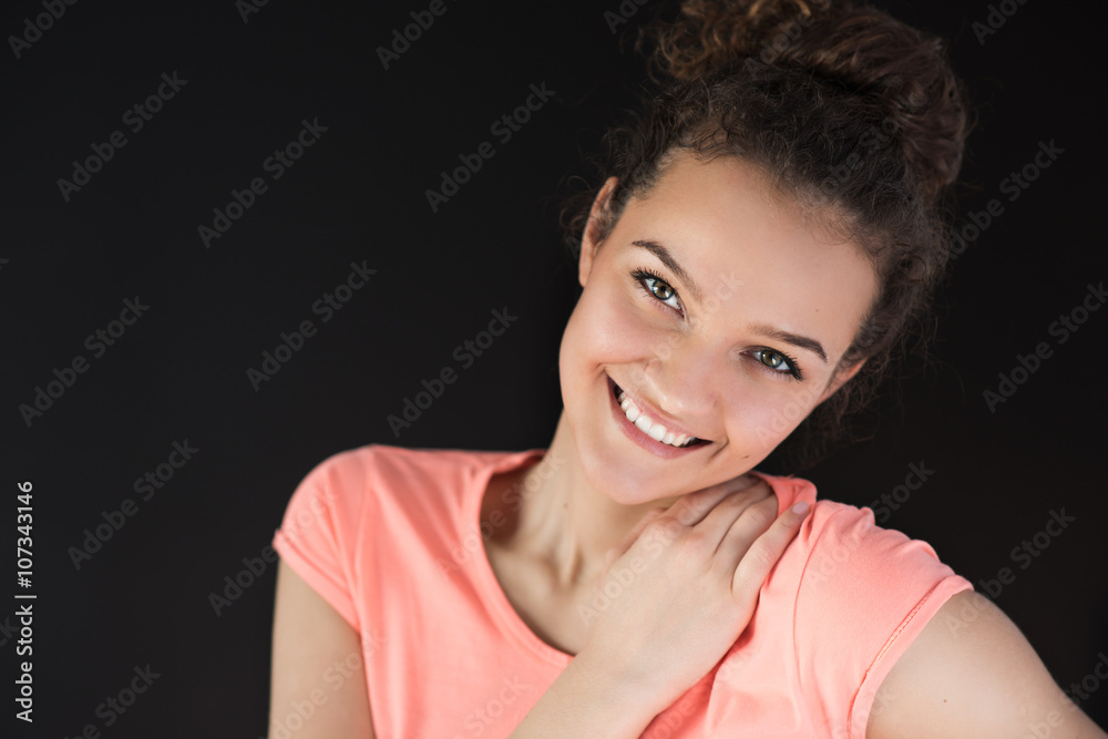 Smiling and beautful face of young woman on black background Smiling and beautful face of young woman on black background