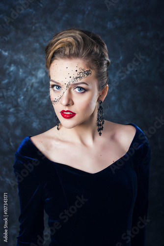 Portrait of attractive girl with art makeup posing on a dark background in the studio. Different emotions and poses. Quality Face Retouch. The huge size of the image.
