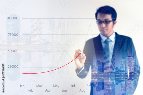 Double exposure of Businessman drawing a growing financial graph.