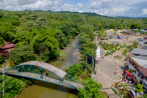 Beautiful overview of charming bridge crossing jungle river and large forest sorroundings. located in Tena, Ecuadorian Amazon region