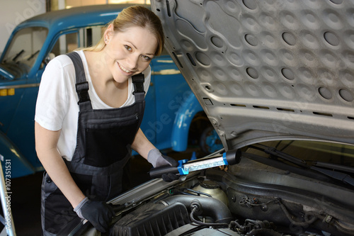 Kfz-Mechaniker bei Reparatur von Motor in Auto-Werkstatt  photo