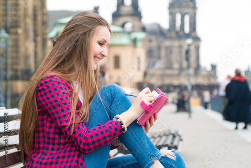 Photography Woman tourist writes his impressions in a diary, Dresden, German