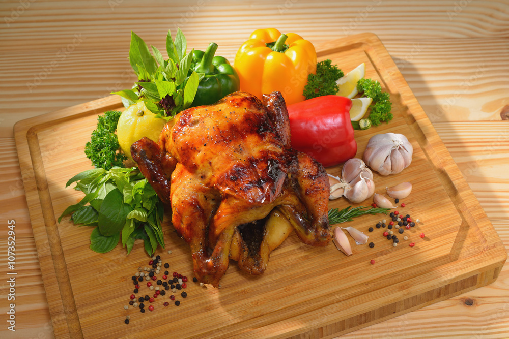 Roast chicken and various vegetables on a chopping wood