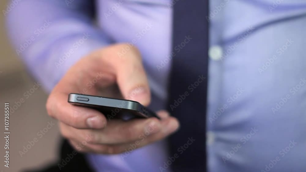 close-up man's hands using mobile phone touchscreen and cofee