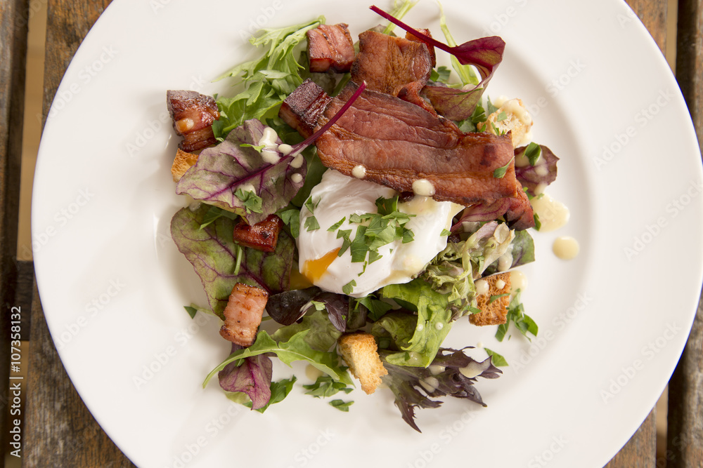 Salad Lyonnaise with pancetta, crisp leaves, softly poached egg, croutons & creamy dressing 
