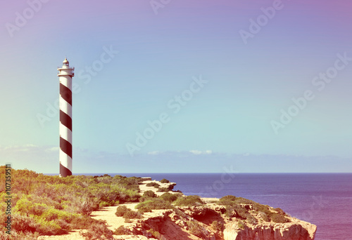 Black and white striped lighthouse on a cliffcoast. Beacon and copy space. photo