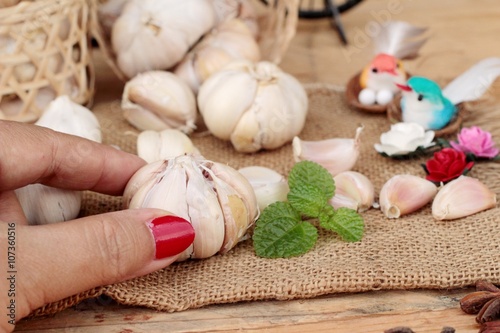 Raw garlic has health benefits on wood background.