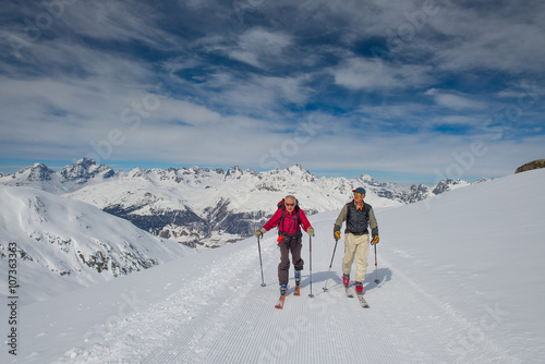 Two elderly men practice ski mountaineering
