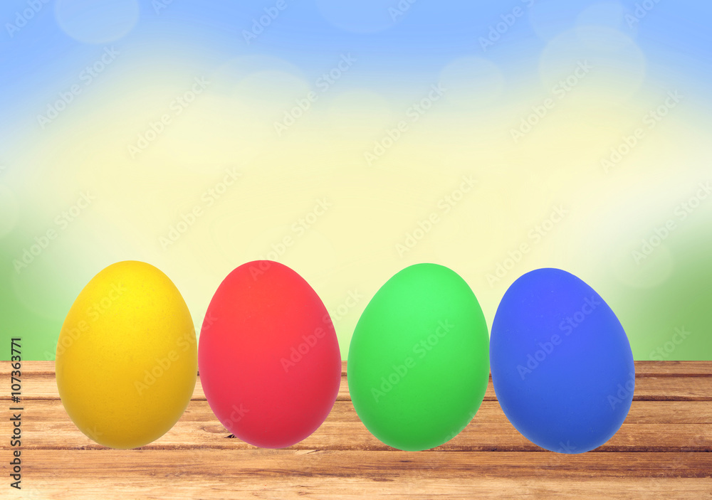 Colorful Easter eggs on wooden table over nature background Colorful Easter eggs on wooden table over nature background
