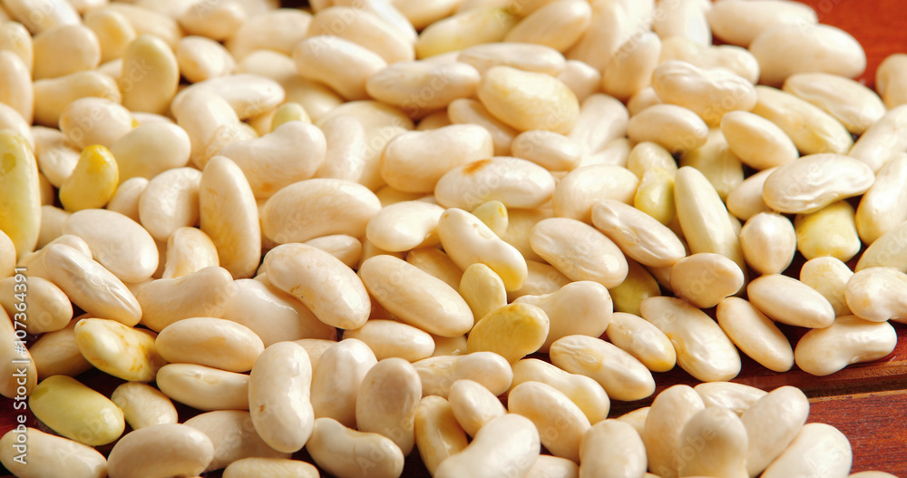 Lots of peeled lima beans lying spread out over wooden surface Lots of peeled lima beans lying spread out over wooden surface