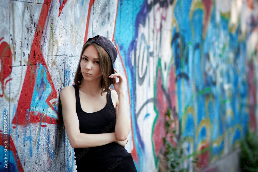 Naklejka premium Young girl on graffiti background