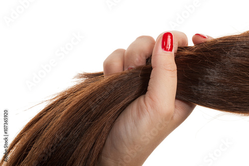 Woman hand holding hair. Isolated on a white background.