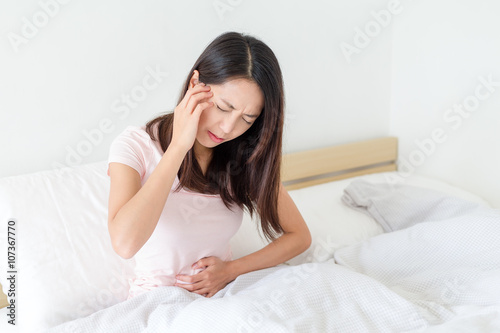 Woman having stomach ache and headache