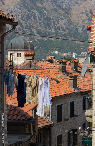 laundry drying on the street between the red roofs of the houses in Kotor, Montenegro