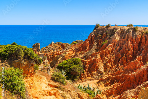 Red rock cliffs on coast of Portugal at Praia de Marinha beach, Algarve region