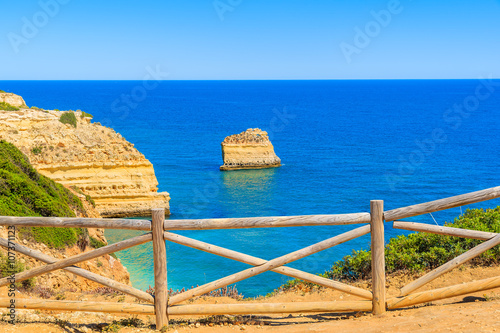 Wooden fence on cliff path on coast of Portugal in Algarve region near Praia de Marinha beach
