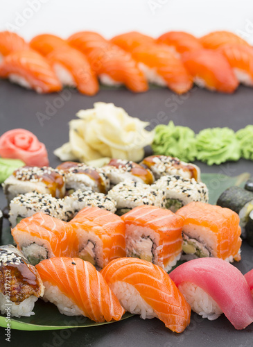 Traditional Japanese food - sushi, rolls and nigiri over black background