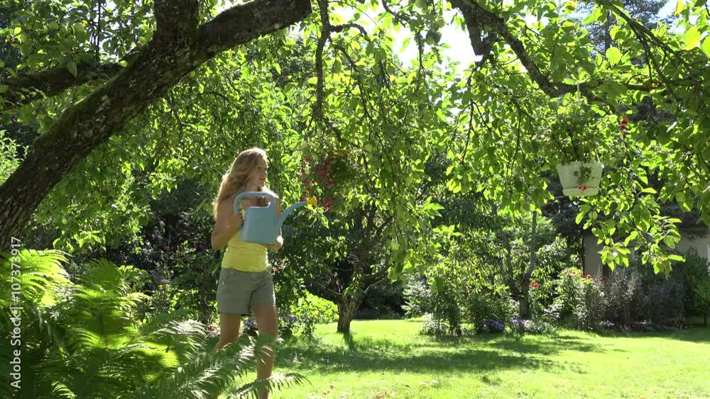 Young blonde florist woman girl water flowers in pots hanging on apple tree in summer house yard. Static shot. 4K
Young blonde florist woman girl water flowers in pots hanging on apple tree in summer house yard. Static shot. 4K