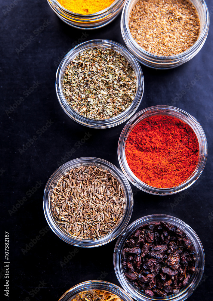 Spices on black background in special jars. Food Spices on black background in special jars. Food