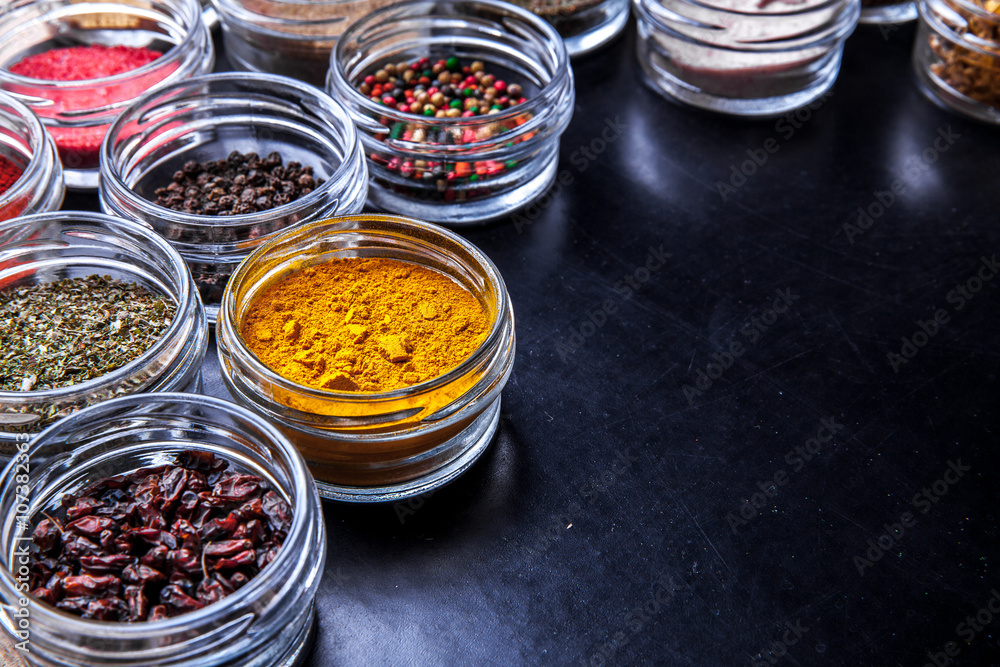 Spices on black background in special jars. Food Spices on black background in special jars. Food