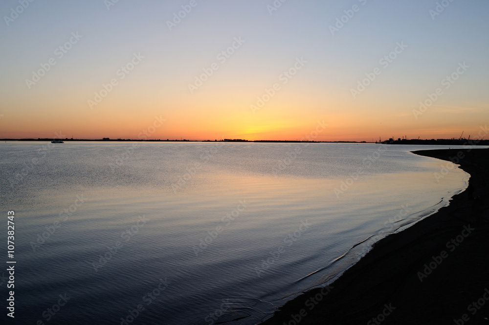 Sunset on a river bank/ Reflection of the sunset in calm waters of a lowland river (Northern Dvina), Arkhangelsk, Russia