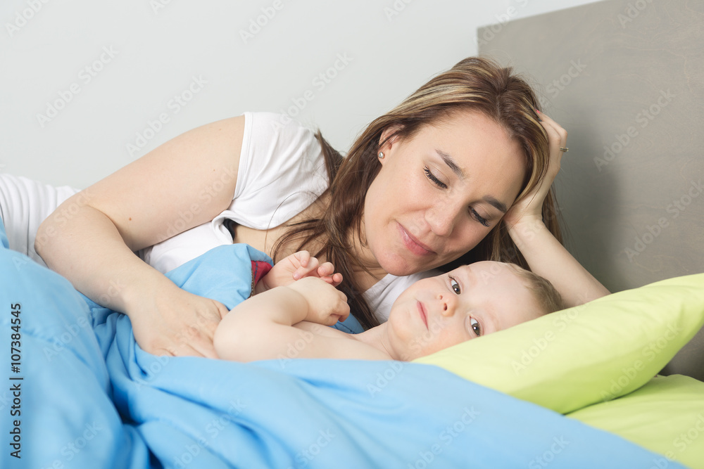 happy family. baby and mother in blue bed happy family. baby and mother in blue bed