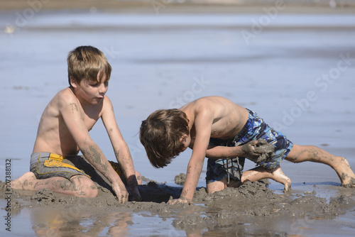 Hermanos Jugando en la Playa con Arena  photo