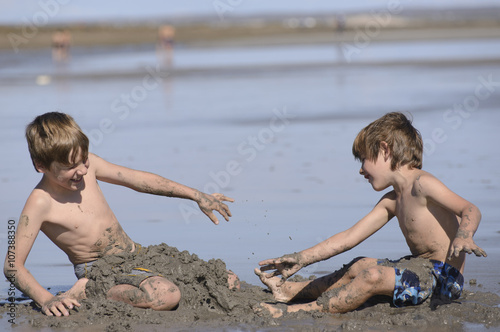 Hermanos Jugando en la Playa con Arena  photo